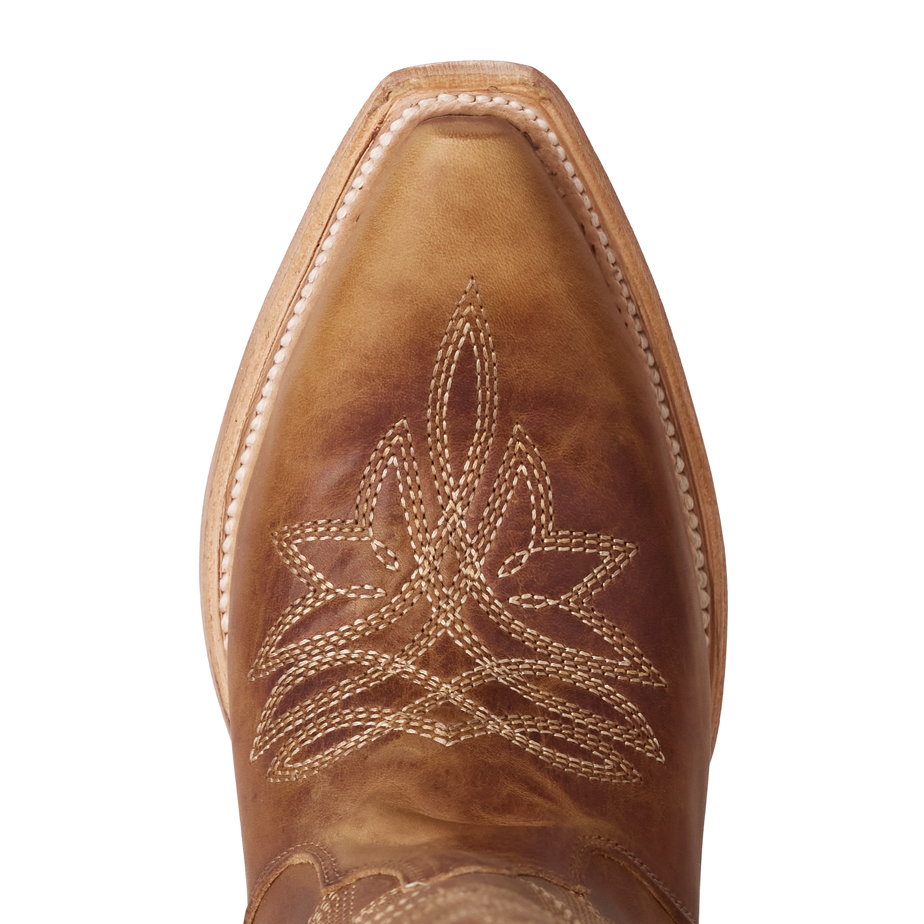 Close-up of a tan leather cowboy boot toe featuring an intricate stitched design with layered, leaf-like patterns and decorative white welt stitching along the edge