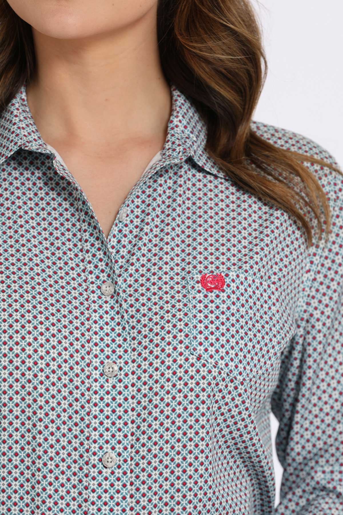 Close-up of a woman wearing a gray button-down shirt with a small multicolor geometric pattern and a pink logo displayed on a white background.