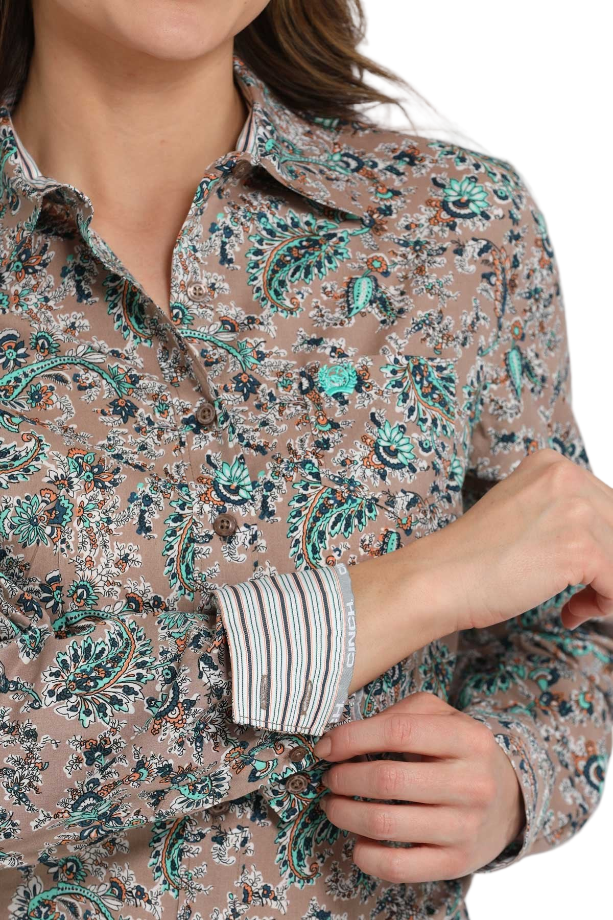 Close-up of a woman wearing a patterned long-sleeve button-down shirt with contrasting cuffs