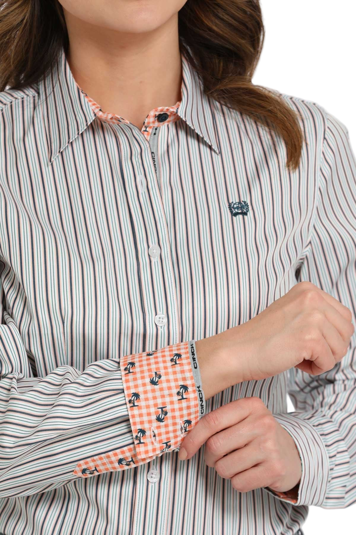 Woman wearing a light patterned long-sleeve button shirt with contrasting cuffs