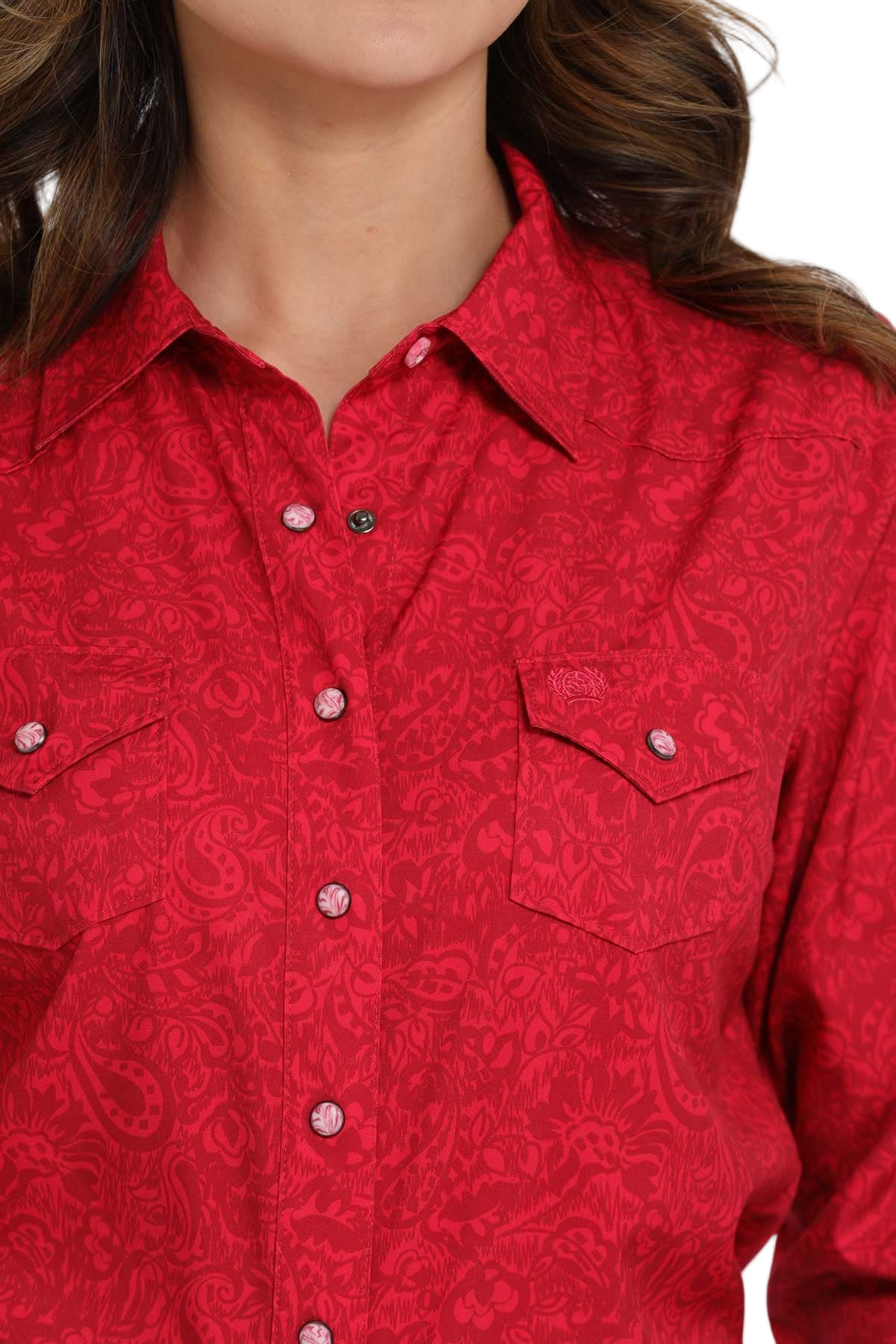Close-up of a woman wearing a red long-sleeve button-down shirt with an allover pattern