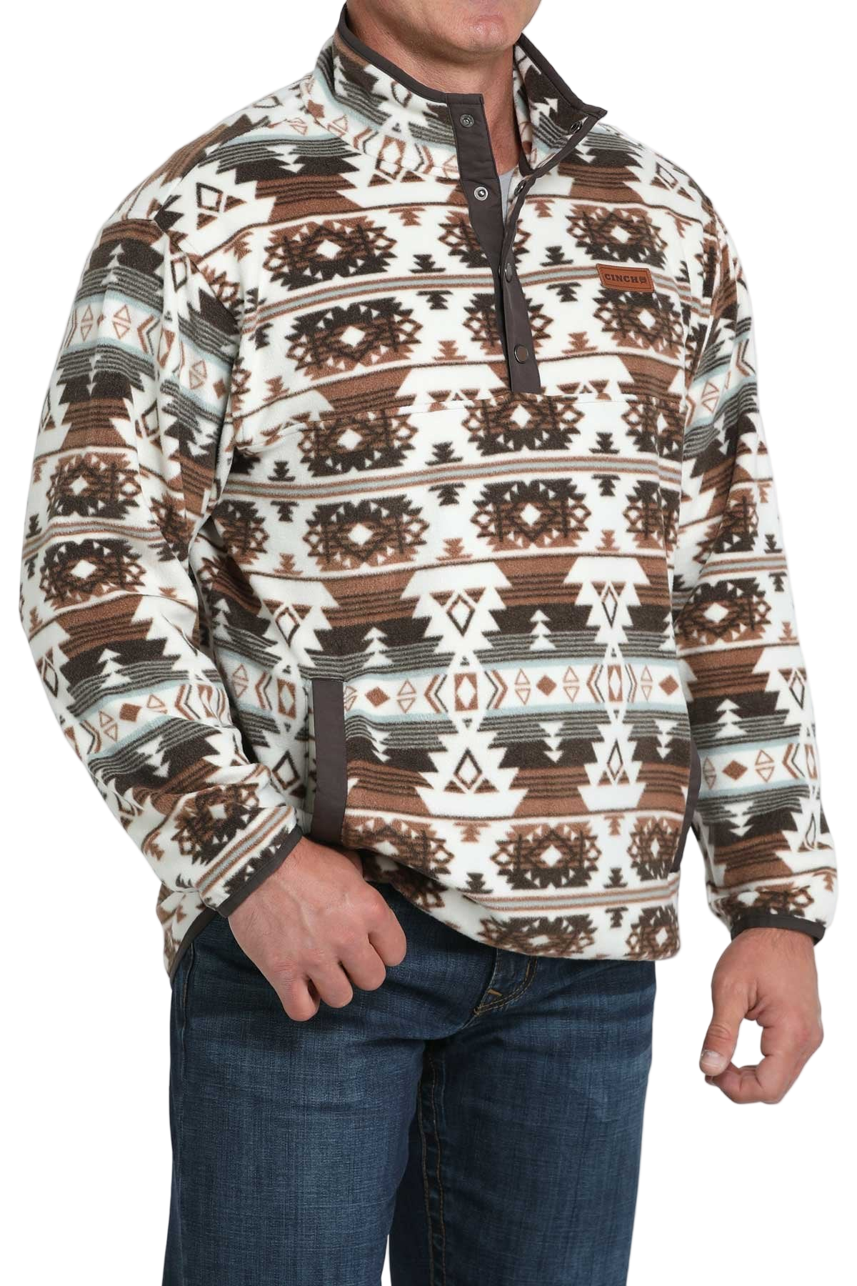 Man wearing a brown and white Aztec-pattern pullover with a snap-up collar, paired with blue jeans